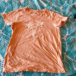 peach t-shirt, with palm tree figures